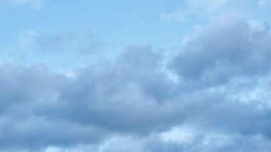 Bulutlar zaman aşımına uğrar. Beyaz kabarık bulutlar mavi gökyüzünde hareket eder