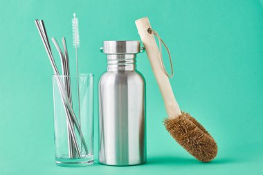 Sıfır atık. Çevre dostu yeniden kullanılabilir eşyalar alüminyum şişe ve yeşil arka planda cam tüpler.