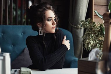 Kafedeki ya da restorandaki kadın pencereye bakar.