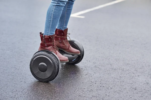 Close up of woman using hoverboard on asphalt road. Feet on elec — Stock Photo, Image