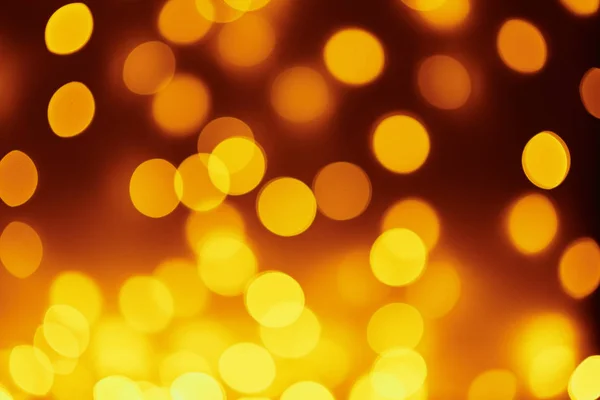 Fondo de luces doradas en un bokeh. Luces difusas abstractas desenfocadas — Foto de Stock