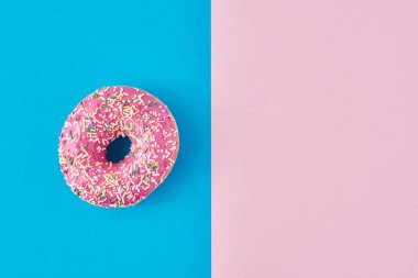 Pastel pembe ve mavi arka planda donut. Minimalizm yaratıcı yemek kompozisyonu. Düzleştirme biçimi