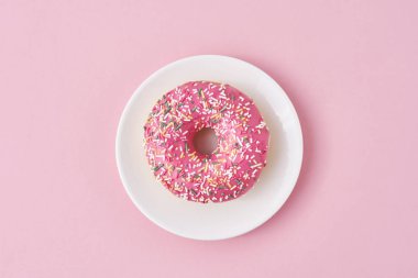 Süslü süslemeler ve pembe arka planda beyaz tabakta krema. Yaratıcı ve minimalis gıda konsepti, üst görünüm düzlük