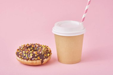 Bir fincan kahve ve pembe arka planda donut.