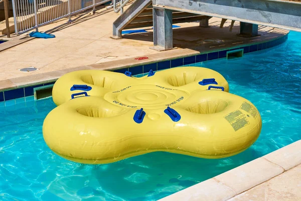 Gele opblaasbare praalwagen in blauw zwembad in het waterpark — Stockfoto