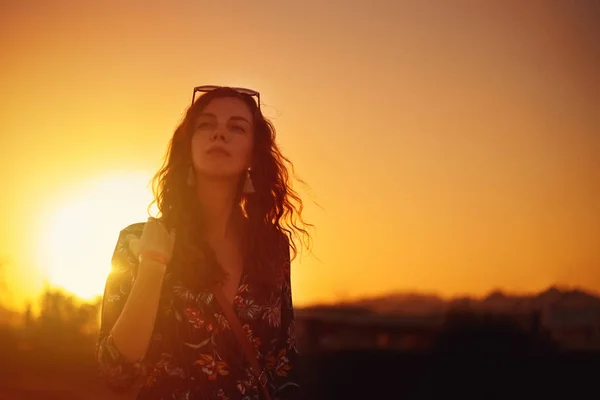 Silueta de mujer rizada joven caminando al aire libre al atardecer — Foto de Stock