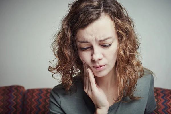 Mujer que sufre de dolor de muelas. Un concepto de dolor dental — Foto de Stock