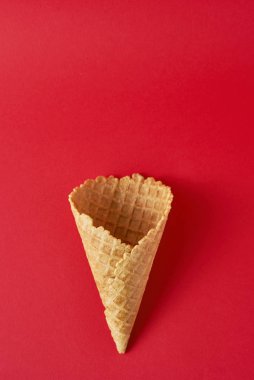 Kırmızı arka planda boş dondurma külahı, üst manzara düz. Minimalizm stili yaratıcılık kavramı