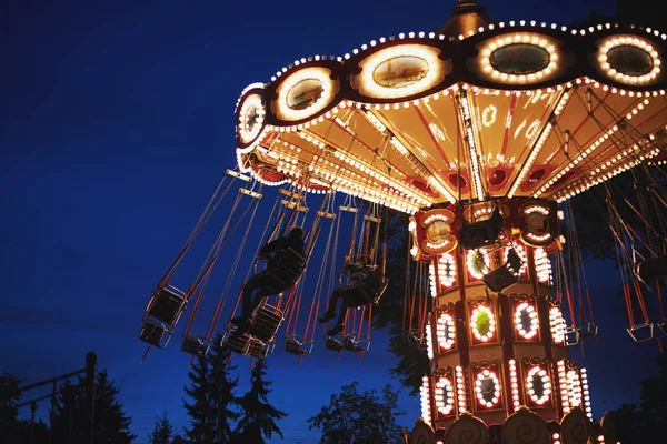 Giostra Merry-go-round nel parco divertimenti in una città di notte — Foto Stock