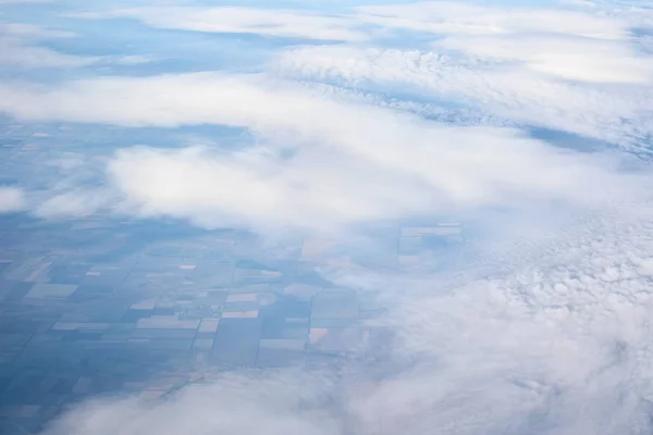 Blue cloudy sky, view from the airplane window. Aerial view of c