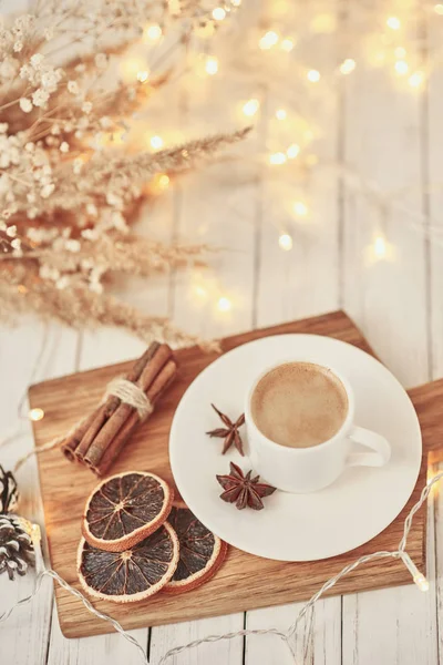 Tasse Kaffee mit Lichtergirlanden und Dekoration auf dem Tisch. Gemütliches Wohnkonzept — Stockfoto