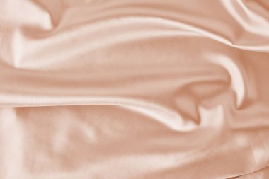 Katlı açık pembe ipek arka plan. Dalgalanan saten yüzeyin soyut dokusu