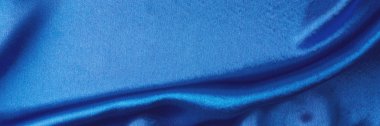 Kıvrımlı mavi ipek arka plan. Dalgalanan saten yüzeyin soyut dokusu, uzun pankart