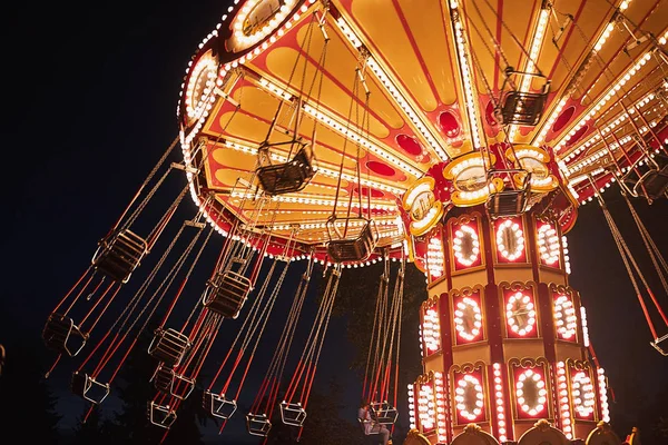 Подсветка карусели цепи свинга в парке развлечений ночью — стоковое фото