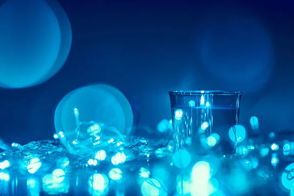 Silueta de vela encendida con luces borrosas doradas sobre fondo oscuro, foto tonificada en azul — Foto de Stock