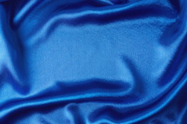 Kıvrımlı mavi ipek arka plan. Dalgalanan saten yüzeyin soyut dokusu