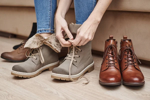 Mujer elige zapatos cómodos entre un montón de pares diferentes — Foto de Stock