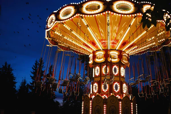 Carrossel Merry-go-round no parque de diversões em uma cidade noturna — Fotografia de Stock