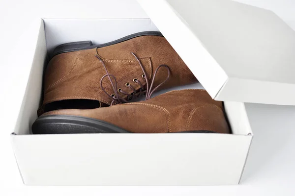 Par de nuevas botas de cuero marrón para mujer en caja abierta sobre fondo blanco — Foto de Stock