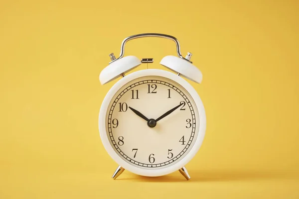 Reloj despertador retro blanco en el fondo amarillo con espacio de copia — Foto de Stock