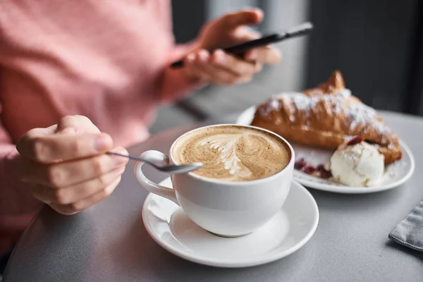 Woman have breakfast in caffe and using smartphone. Girl chattin