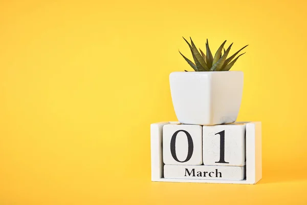 木块日历，日期为3月1日，种植在黄色背景上。春天的概念 — 图库照片