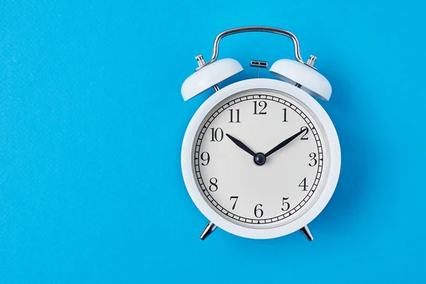 Relógio de alarme branco vintage no fundo azul com espaço de cópia . — Fotografia de Stock