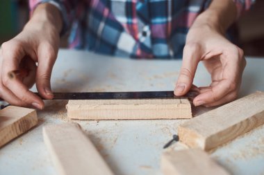 Marangoz elleri tahta kalemle ölçü alıyor. Diy ahşap işçiliği ve mobilya yapımı kavramı