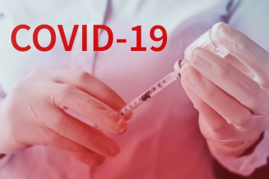 Anti COVID-19 aşı konsepti. Kadının elinde şırınga ve ilaç ampulü var. Virüs koruması