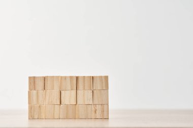 Beyaz arka planda tahta bloklardan yapılmış duvar. Görev konsepti bitiriliyor