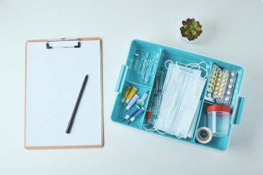 Tıbbi malzemelerin üst görüntüsü ve beyaz arkaplanda boş kağıt sayfası. Sağlık ve Tıp Konsepti