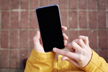 Şehir dışında akıllı telefon kullanan bir kadın, kapatın. Cep telefonunda mesaj yazan kadın eller