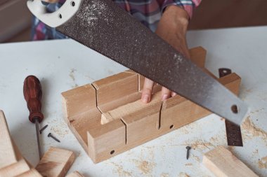 Marangoz ellerinin tahta testereyle kesme işlemi. Diy ahşap işçiliği ve mobilya yapımı kavramı