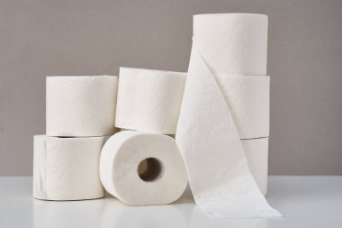 Gri arka planda istiflenmiş tuvalet kağıdı ruloları. Hijyen kavramı
