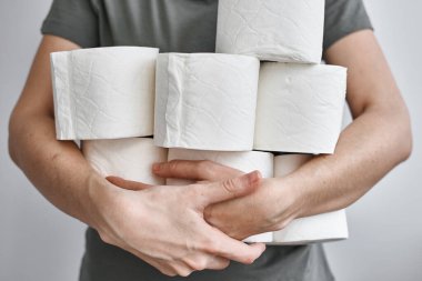 İnsanlar Crownavirus karantinası için tuvalet kağıdı stokluyorlar. Kadının elinde bir sürü tuvalet kağıdı var.