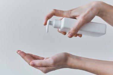 COVID-19 salgını antiseptik içeren sağlık koruma kavramı. Koronavirüs için önlem olarak dezenfektan ya da antiseptik jel kullanan kadın ellerini yıkıyor.