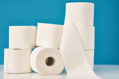 Mavi arka planda istiflenmiş tuvalet kağıdı ruloları. Hijyen kavramı