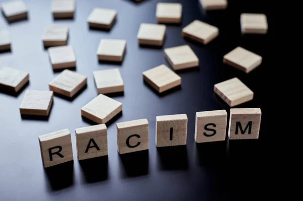 种族主义的概念和人与人之间的误解 偏见和歧视 在黑色的背面涂上种族主义字样的木块 — 图库照片