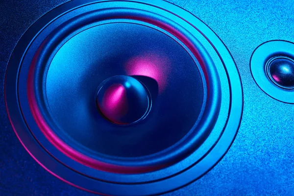 Sound audio speaker with neon lights on dark background. Dynamic monitor closeup. Creative backgroound