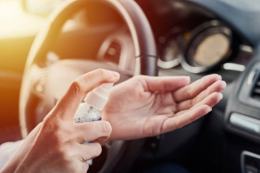 Sürücü dezenfekte eli ve araba sürmeden önce antibakteriyel dezenfektan. Koronavirüs önleyici önlem