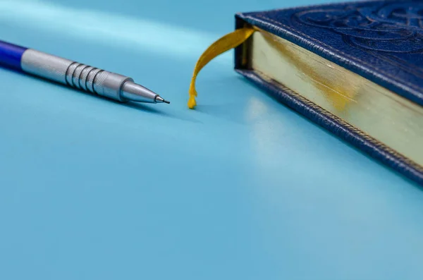 Blue leather notebook in and a mechanical pencil on a turquoise — 스톡 사진