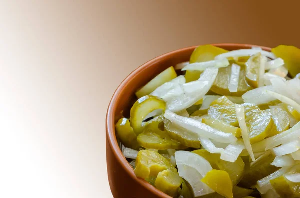 Pickled cucumbers with raw onion slices in a clay bowl. Deliciou — Stock Photo, Image