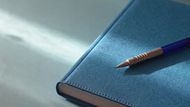 Caderno Caneta Uma Mesa Junto Janela Close Caderno Azul Fechado — Vídeo de Stock