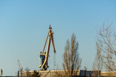 Liman portalı vinci. Liman ve depolama alanında yüksek vinç var. Güneşli bir günde çekim yapmak. İnsanlar olmadan. Seçici odak.