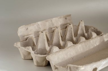 Boş karton yumurta tepsisi. Beyaz arka planda on tavuk yumurtası tepsisi. Plastiği durdur. Yan görüş. Seçici odaklanma. Yakın plan..