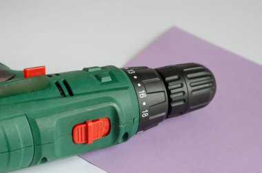 Matkabı olmayan bir elektrikli matkap masanın üzerinde yatıyor. Anahtarsız bir Chuck 'ın yakın çekimi. Seçici odaklanma. Göz hizası atışı.