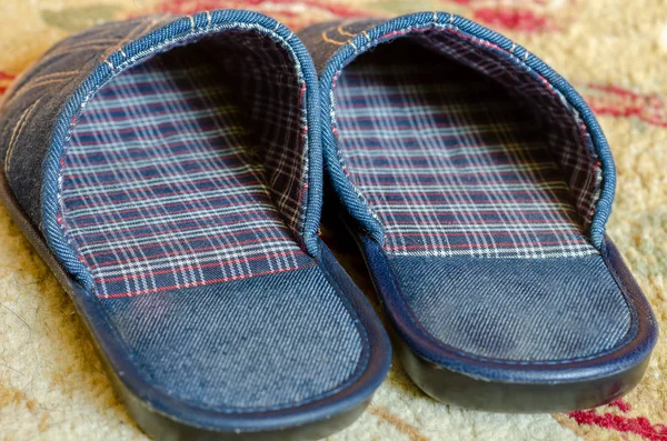 Dark blue room slippers on the carpet. — Stock Photo, Image