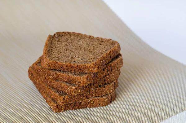 Una pila de finas rebanadas de pan de centeno sobre una mesa beige . —  Fotos de Stock