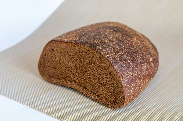 Media barra de pan de centeno sobre un fondo claro . —  Fotos de Stock