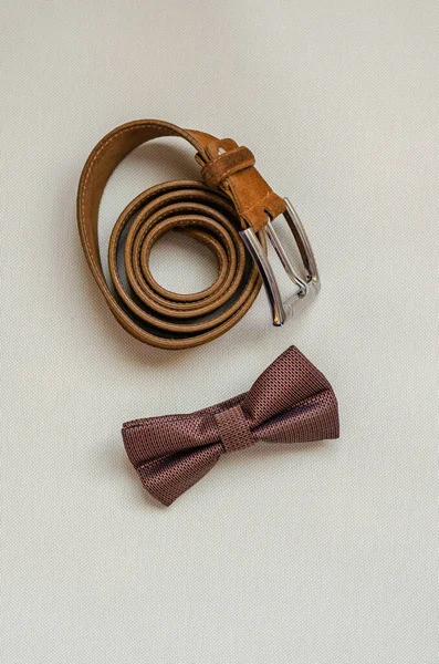 Bow tie and leather belt on a light background. — Stock Photo, Image